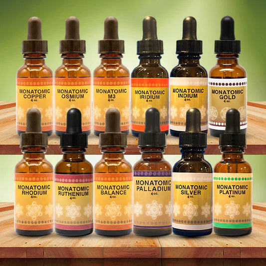 Collection of Monatomic element bottles on a wooden surface with a green gradient background